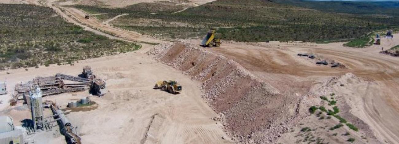 A aerial shot of an open pit mine in the desert.