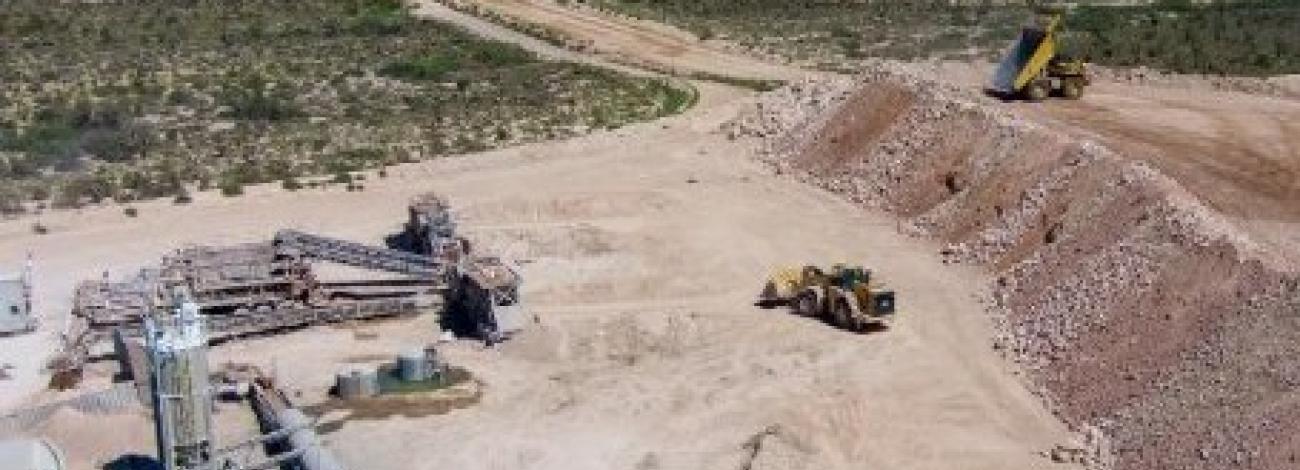 A aerial shot of an open pit mine in the desert.