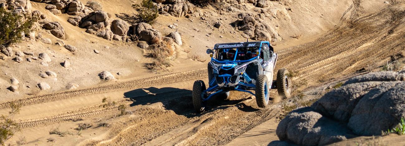 a side by side drives through a dirt trail.