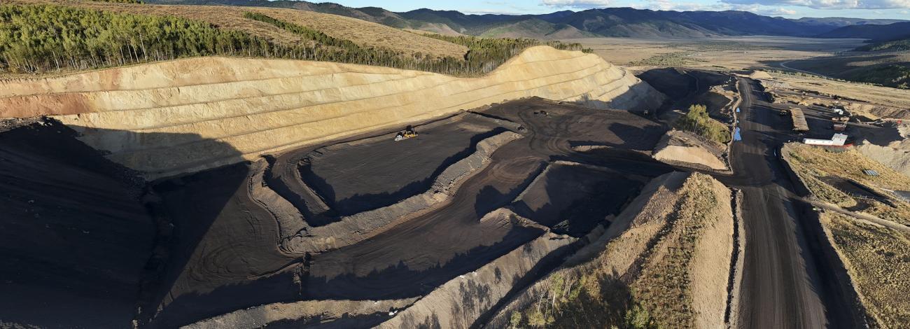 Phosphate mining with horizon, trees, mountains, clouds and sky in background