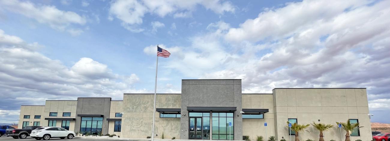 A federal building with a flag and parking lot