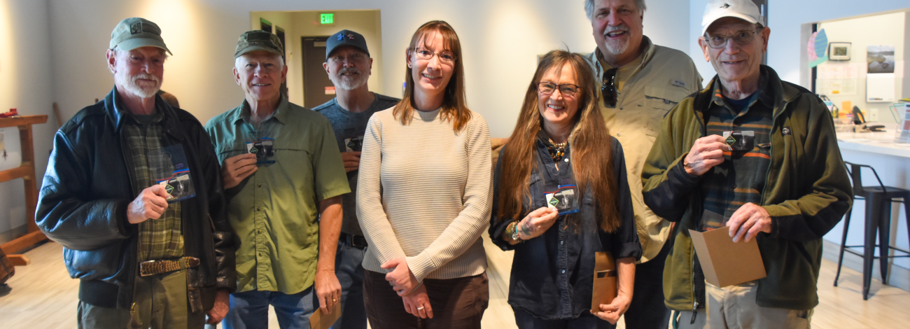 A group of people hold up America the Beautiful passes