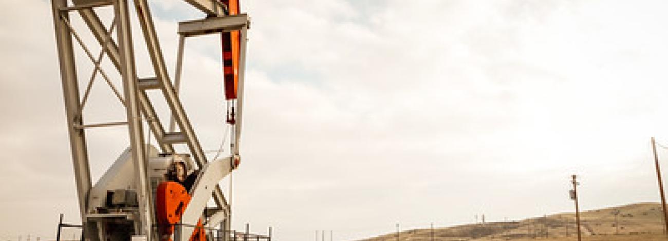 An Oil Derrick in dry hills.