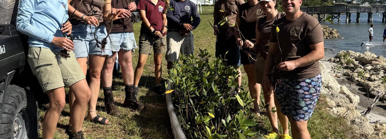 Group of people standing together outside with plants