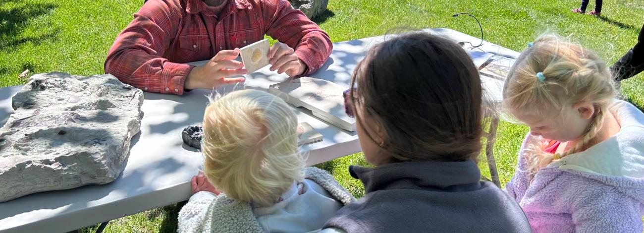 Kids handle fossils at a story time event in Pinedale WY with BLM staff member