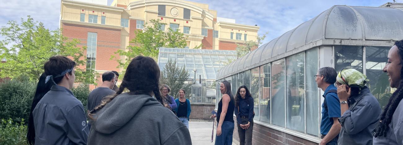 Image of students on campus in front of greenhouse