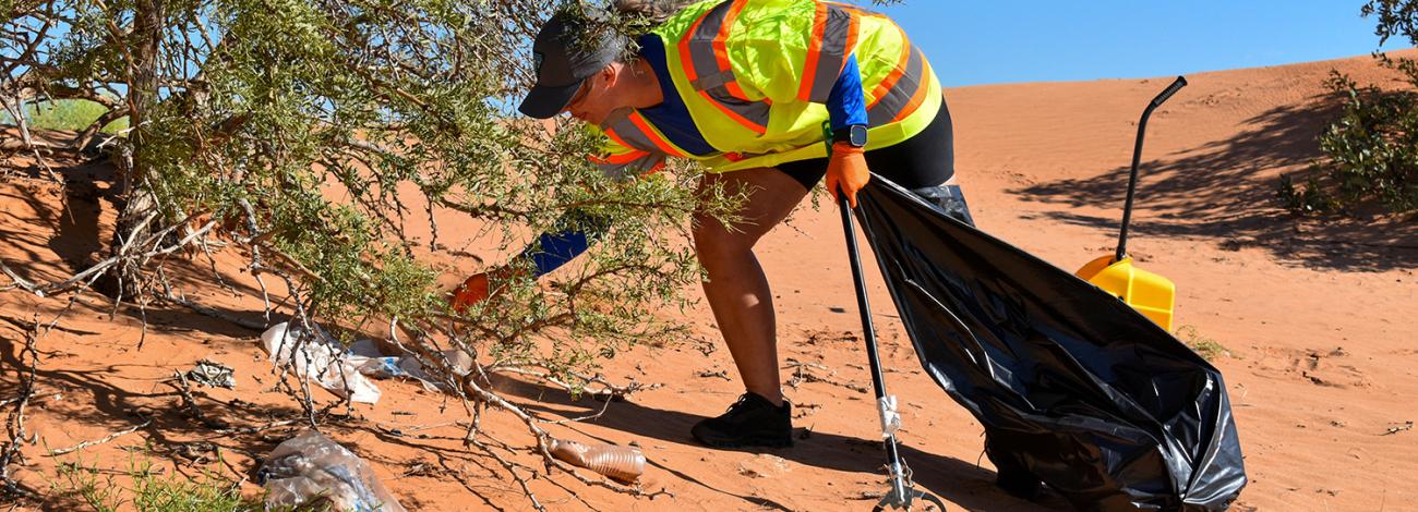 A volunteer picking up litter at the 2026 NPLD event in Carlsbad.