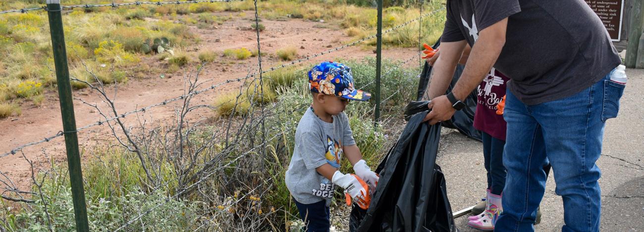 The public picking up litter along a fence line at National Public Lands Day 2025.