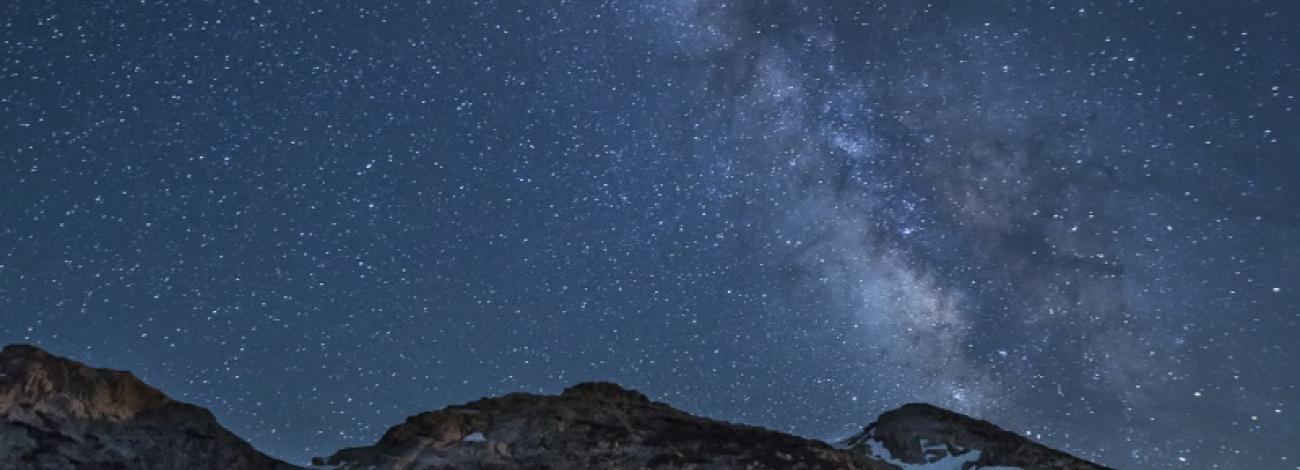 Mountain range at night with starry sky above