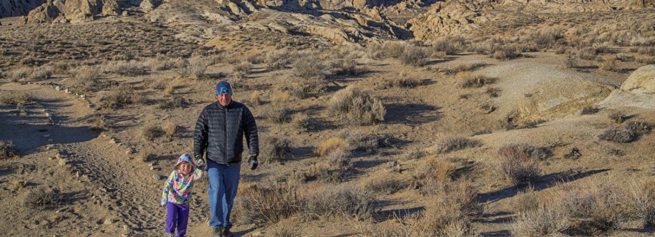two people walking near a mountain