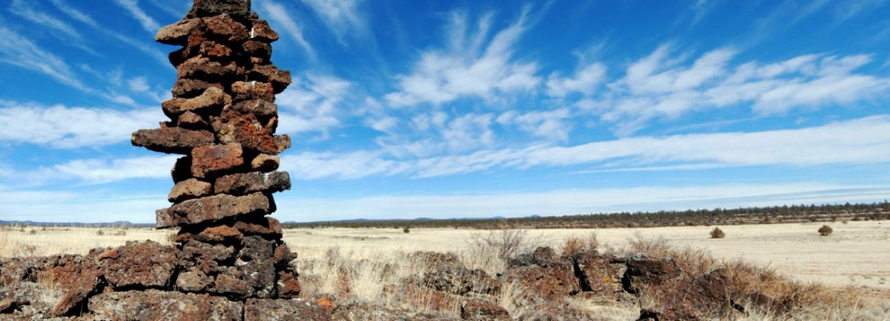 A rock cairn against a blue sky in New Mexico.