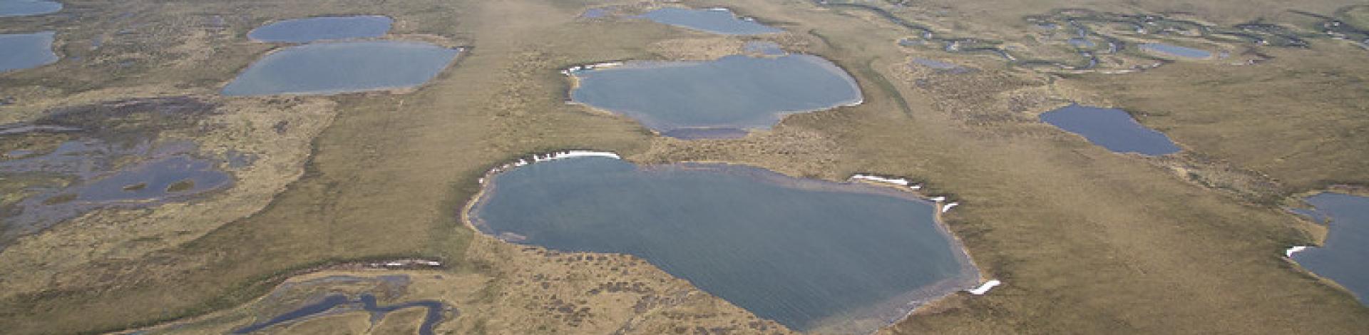 Aerial photo of lakes and rivers on the tundra landscape in the Northeast National Petroleum Reserve in Alaska.