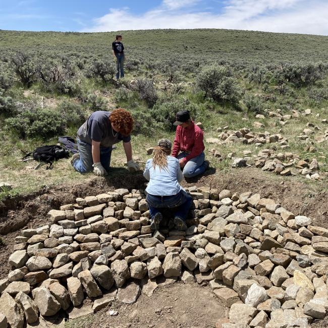 workers install rock structure in streambed