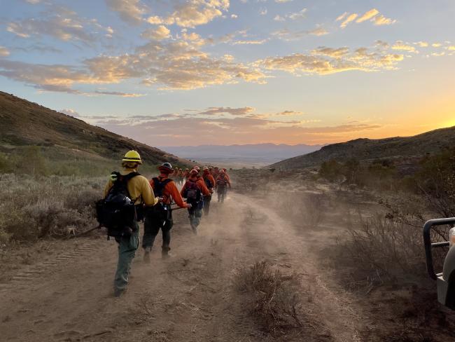 Fire Crew hiking into the sunset.