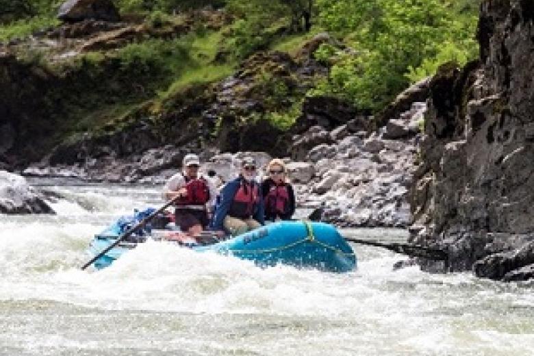 group of people floating in a boat on a river