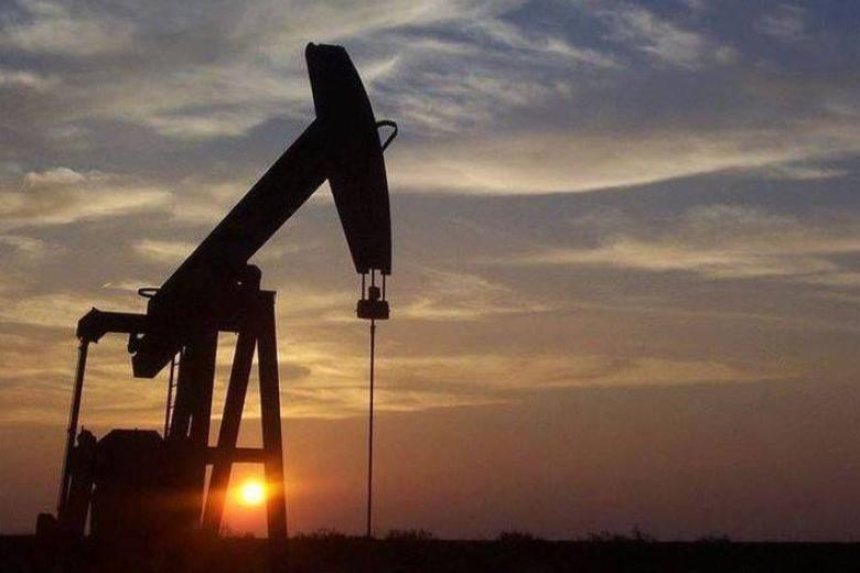 Oil and gas rig in front of a sunset.