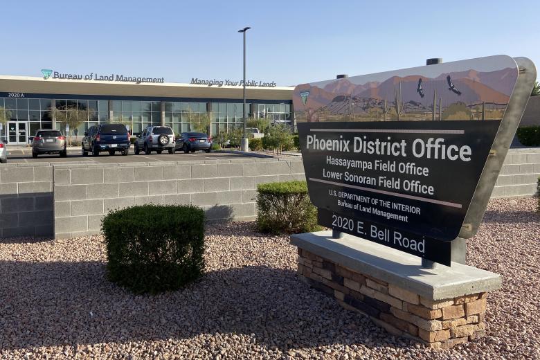a view of an office building with a sign that reads Phoenix District Office, Hassayampa Field Office, Lower Sonoran Field Office, U.S. Department of the Interior, Bureau of Land Management