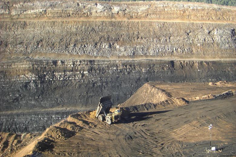 Bulldozer at edge of Dry Valley Mine gorge.  Gorge is striated in color. 