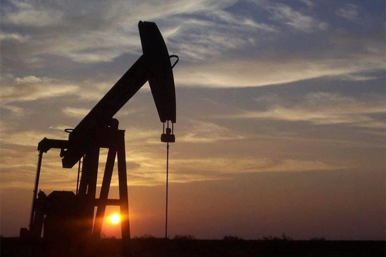 Silhouette of an oil and gas pump jack at sunset