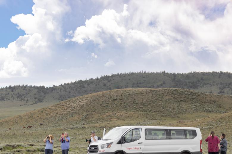 students view the wild horses in the field at the Green Mountain Herd Area