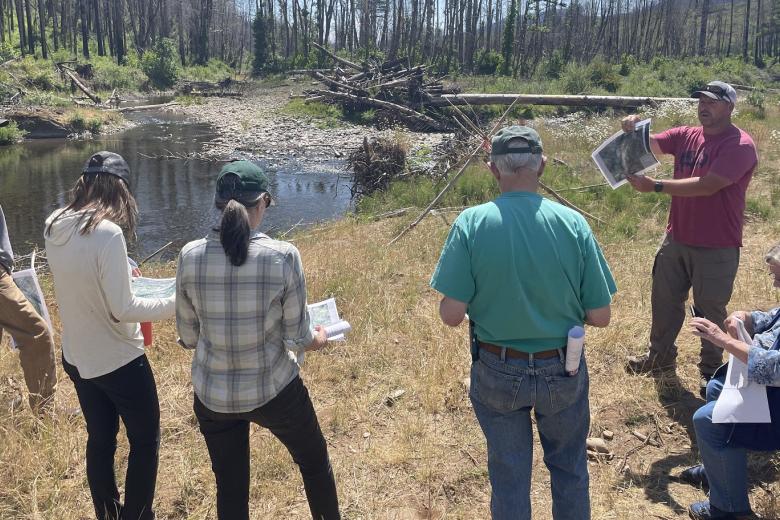 photo of RAC members meeting in a forest near a stream