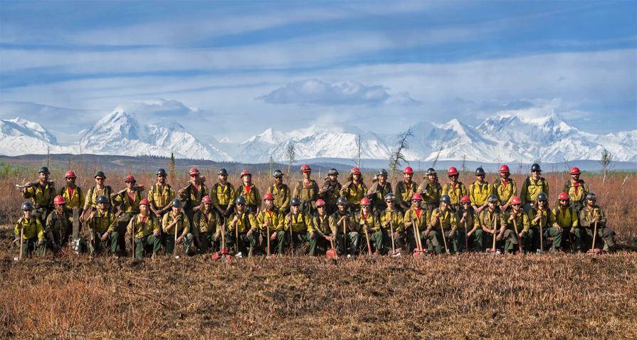 Wildland firefighters in a field in front of mountains