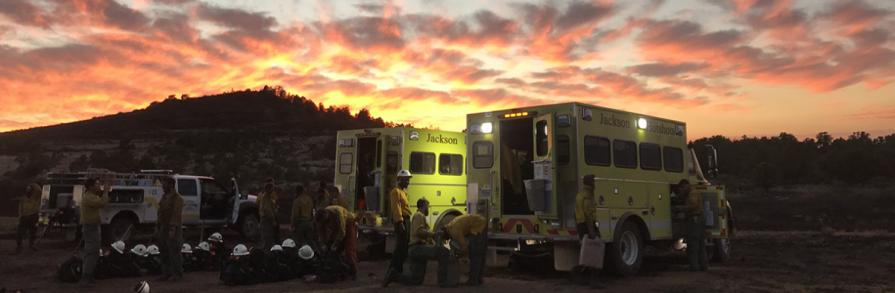 Jackson fire crew standing near engine at sunset
