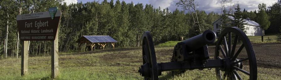 Fort Egbert sign, cannon, and buildings in the distance