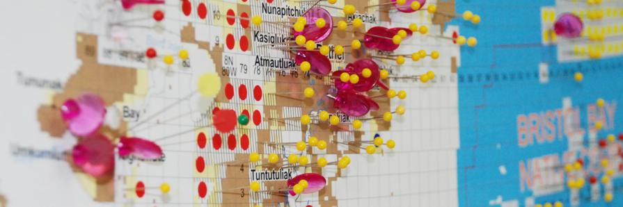 Close up of Alaska land transfer map showing pins, stickers, and colored in areas of status