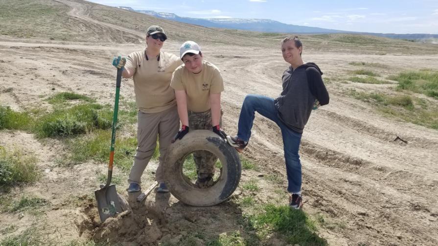 Volunteers stand with tires collected during volunteer cleanup project