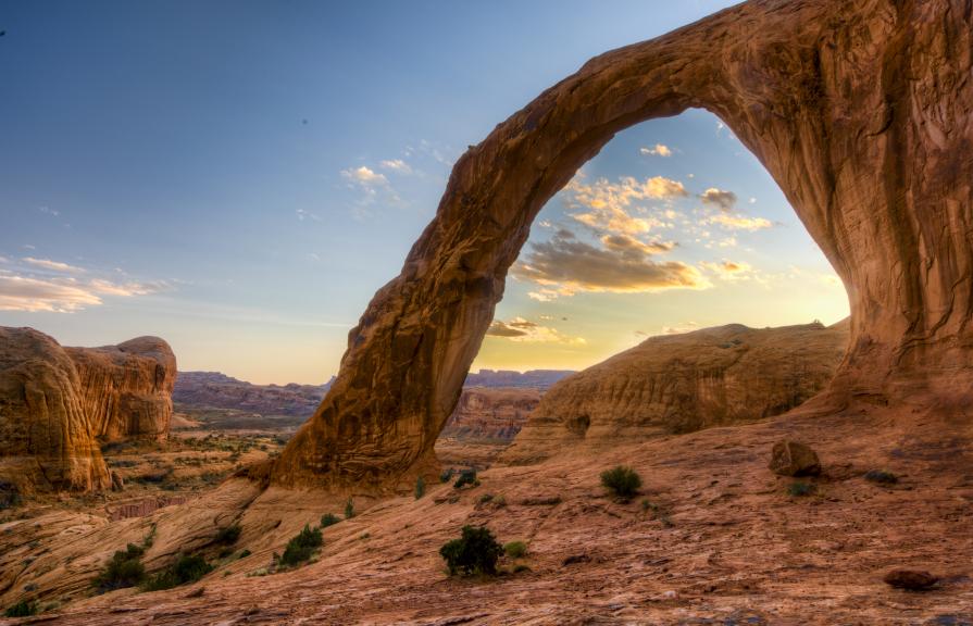 A rock arch framing a cloud