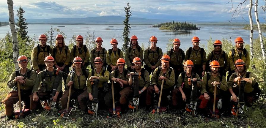 Crew group photo in front of a lake.