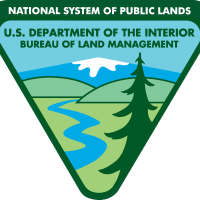 The BLM Official Logo displaying an inverted triangle with a pine tree, snow capped mountain, a river an hills.