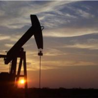 A oil and gas pump jack located in Wyoming with sunset background