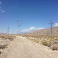 Road in the desert with power lines. 