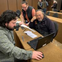 Three people looking at a laptop