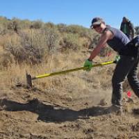 A volunteer clears an trail with a hoe.  Photo by Stan Bales, BLM.