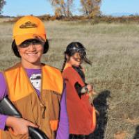 Two girls wear bright vests while learning to hunt on public lands. (Eric Coulter/BLM)