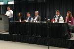 Coastal Plain Oil and Gas Leasing Program EIS Fairbanks Scoping Meeting where Joe Balash speaks to the audience from a podium on a stage with a panel of DOI, BLM, and USFWS employees.