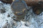 Well head cut, plugged, and a cap with identification plaque welded in place at Point Simpson 