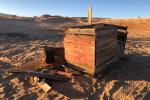 A old wooden chicken coop at a recreation site. Chicken wire and hold boards are shown.