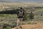 Uniformed BLM law enforcement ranger stands on vista