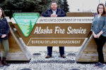 Three people standing by sign