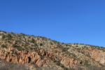 looking across at a rocky area with many green trees dotting the hillsides