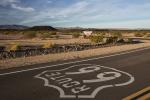 Up-close view of Route 66 with hills and brown dirt in the background.