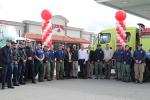 Interagency Fire Prevention partners stand in front of the Maverick store with red and white balloons and a fire truck in the background. 