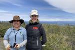 BLM’s Pine Hill Preserve Manager Graciela Hinshaw stands with Margaux Blanc. A field of brush is in the background. 