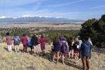 A group of students looking out at the scenic Colorado landscape with mountains in the distance. 