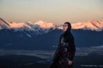 Autry Lomahongva (an Indigenous youth) stands on the landscape with mountains in the background. 