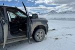 A pickup truck is pointed to look out across the Arctic landscape.